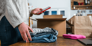 Woman packing sold clothes in box